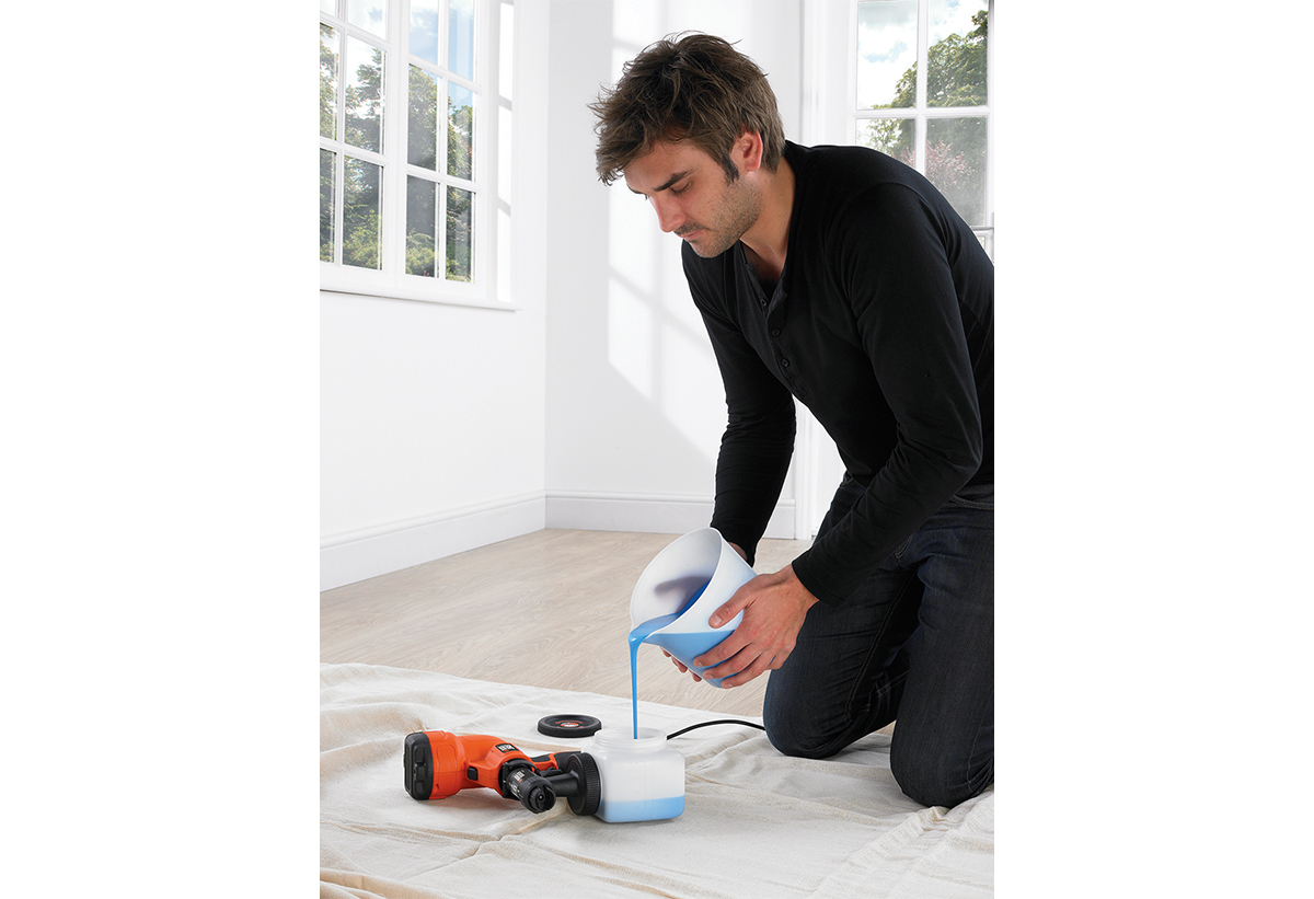 Απεικονίζεται άνδρας να γεμίζει το δοχείο χρώματος.